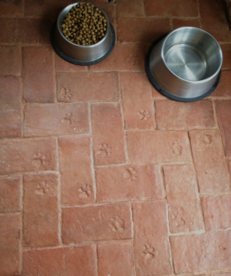 Thin brick floor tile with stamped paw prints
